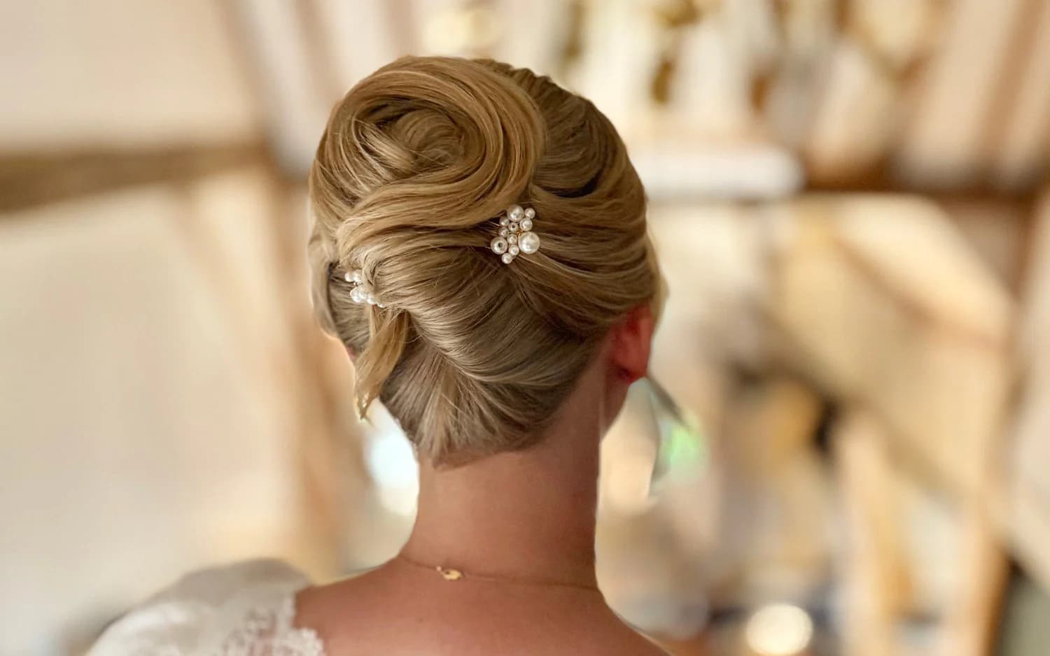 A bride's low chignon with pearl pins, by Sabrina Duparcq